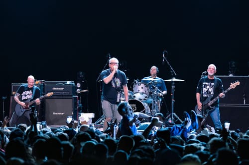 Punk rock band Descendents all standing on stage playing concert